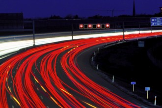 Many cars drive on a motorway at night and create light trails. Austria