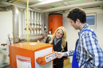 Young heating technician in boiler room at Heizanlage Austria