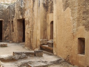 Tomb doors and niches in a carved sandstone wall forming a street like view in the temple of the
