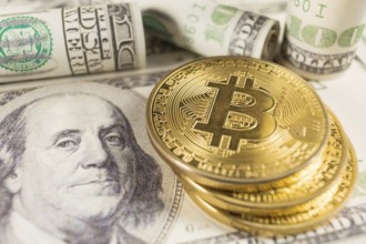 Bitcoin stack and banknotes of one hundred dollar. Conceptual image for global cryptocurrency