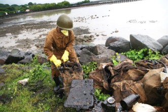 Volunteer cleaning oil spill garbage at elephanta island, Bombay Mumbai, Maharashtra, India NOMR