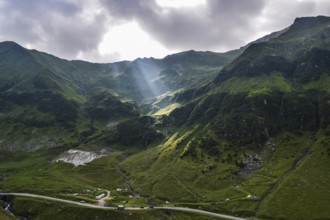 View over the Transfagarasan mountains and the tortuous road with sun rays through the clouds