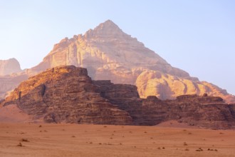 Wadi Rum, Jordan. The orange sand desert landscape and Jabal Al Qattar mountains at dawn, sunset