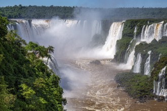 View to Devil's Throat and Iguazu Falls gorge with brown river, white cascading falls and lush