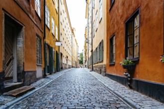 Beautiful old cobblestoned street amidst old colorful houses in Gamla Stan Quarter in Stockholm