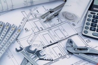 An architect's construction plan with a calculator. Symbolic photo for financing and planning a new