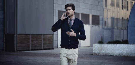 Young businessman talking smartphone phone walking on the street
