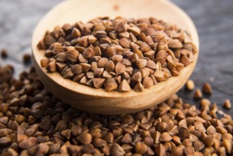 Buckwheat seeds on wooden spoon in closeup, lodz, poland