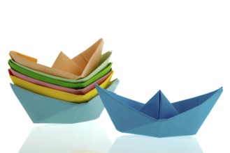 Colorful folded paper boats isolated over white background