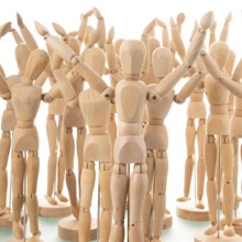 Many wooden mannequins isolated over white