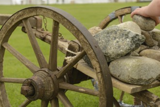 Stones are loaded onto an old wooden cart - close-up