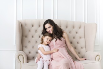 Young happy woman embrace with small daughter. Love and family concept