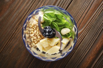 Ingredients for italian national traditional genovese pesto sauce in food processor bowl. Flat lay