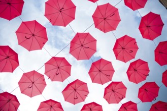 Sky filled with red umbrellas