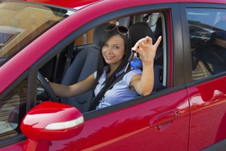 Young woman with new car and car keys