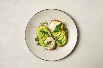 Sandwich with cream cheese, sliced avocado and boiled egg, arugula, on grainy bread, homemade,