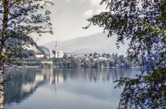View over water of to church of Saint Martin and town, Lake Bled, Bled, Slovenia, former