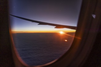 View of the Persian Gulf from the aeroplane window in the evening. Sunset over the clouds. Flight