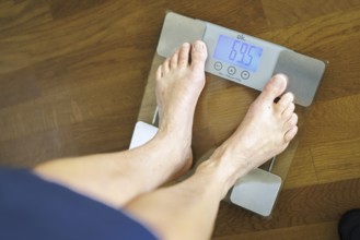 Symbolic photo on the subject of body weight. The feet of a 60-year-old person can be seen next to