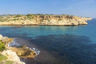 Scenic rocky coastline meeting crystal clear turquoise waters in cales de mallorca, a stunning cove