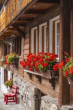 Wooden house with red geraniums in flower boxes in front of the windows, Lake Brienz, Brienz,