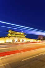 Colorful streaks of light from car lights on moving traffic in front of historic Gyeongbokgung