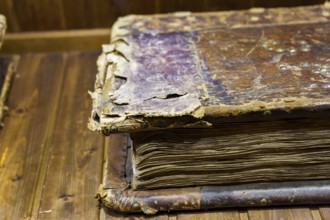 Close-up of an old, worn book on a wooden table