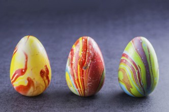 Colorful Easter eggs lined up side by side on a trendy black background
