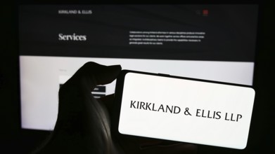 Stuttgart, Germany, 12-15-2023: Person holding mobile phone with logo of American law firm Kirkland