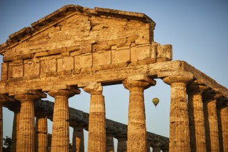Sunset behind ancient columns of a temple with a clear sky, summer evening mood in Paestum, ancient