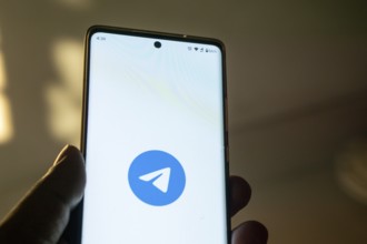Smartphone on surface showing Telegram logo