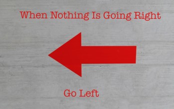 A bright red arrow pointing left on a conrete wall with humorous text