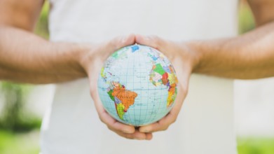 Close up man s hand holding small globe