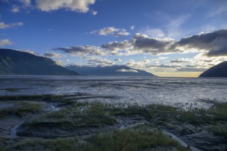 Vast coastal landscape at sunset with calm water under a cloudy sky, Turnagain Arm, Alaska, USA,