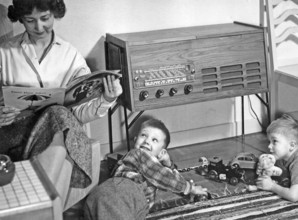 In the 1950s. A mother is seen sitting reading a magazine in her home while her sons are playing