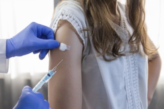 Close up doctor holding syringe and using cotton before make injection to patient in medical mask.
