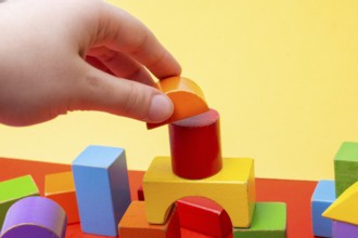 Hand building tower with colorful building blocks