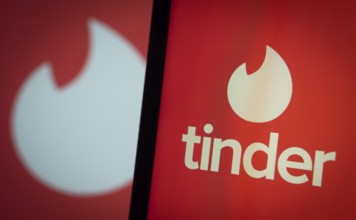 tinder logo is seen on a smartphone