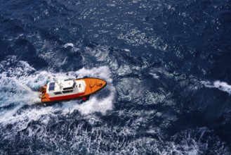 Pilots boat aerial view sailing in blue ocean sea with foam wake