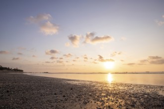 Dreamlike sunset on the dream beach of Kuta, small waves sunset over the sea and the reflection of