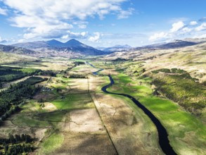 Farms and Mountains over River Dochart and Road A85 from a drone, Perthshire, Scotland, UK