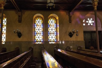 Incidence of light through stained glass windows, star, reflections, wooden benches, Great
