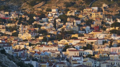 Villas spread over hills, warm light of the rising sun, picturesque and quiet, Symi Town, Symi,