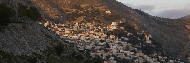 Town in the mountains in the warm morning light, Symi town, Symi, Dodecanese, Greek Islands,