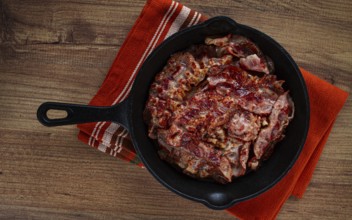 Crispy bacon, on a cast-iron skillet, on a wooden table, rustic style, no people