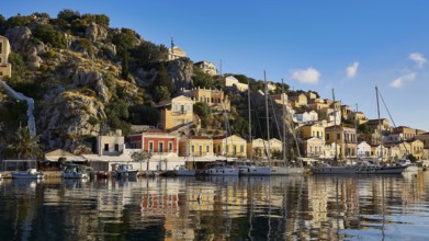 Picturesque building backdrop with boats in the water. Hilly landscape in the background,