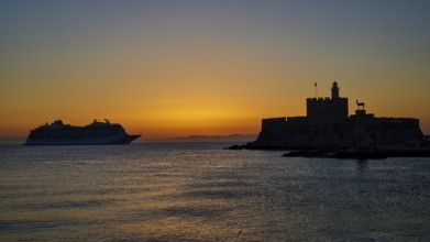 Cruise ship passing a fortress, calm, warm sky, sunrise, dawn, Fort of Saint Nikolaos, Mandraki