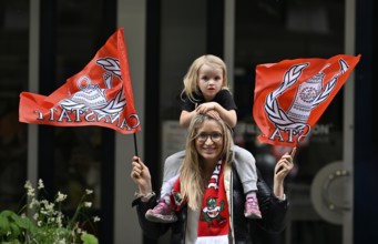 Woman, blonde, with girl, blonde, 4 years, sitting on shoulders, waving flags, flags of VfB