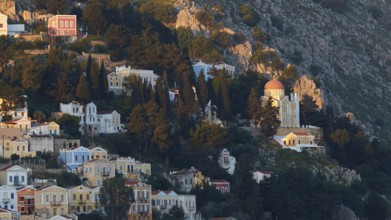 Beautiful mountain village with colourful houses and church surrounded by green vegetation in the