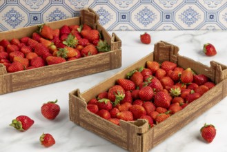 Two full cartons of vibrant red strawberries, blue pattern in the background